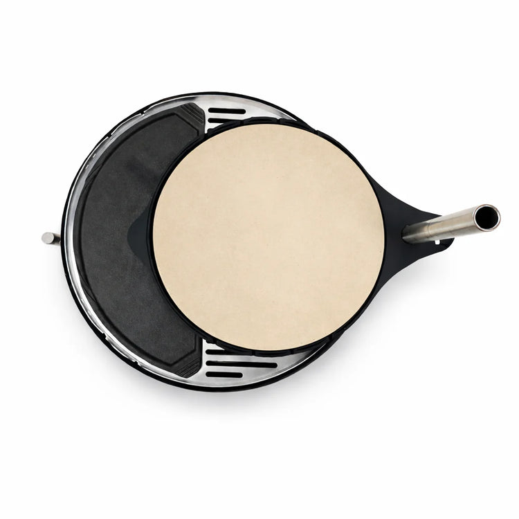 Black waffle maker with a round, flat waffle on a white background