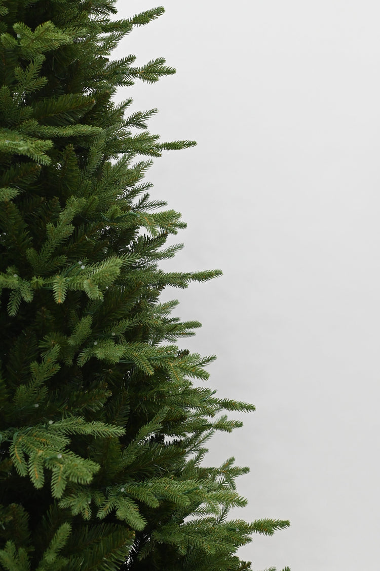 Green artificial Christmas tree against a white background
