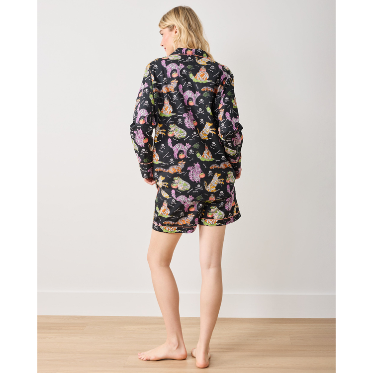 Woman wearing a colorful pajama set with animal pattern on a plain background