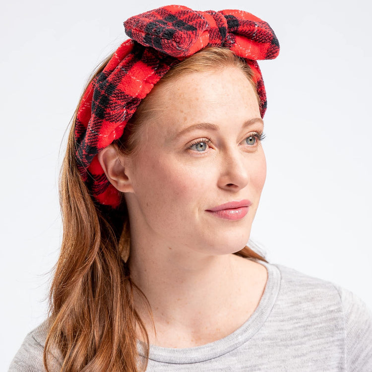 A woman wearing a multicolored geometric patterned headband with a large bow.