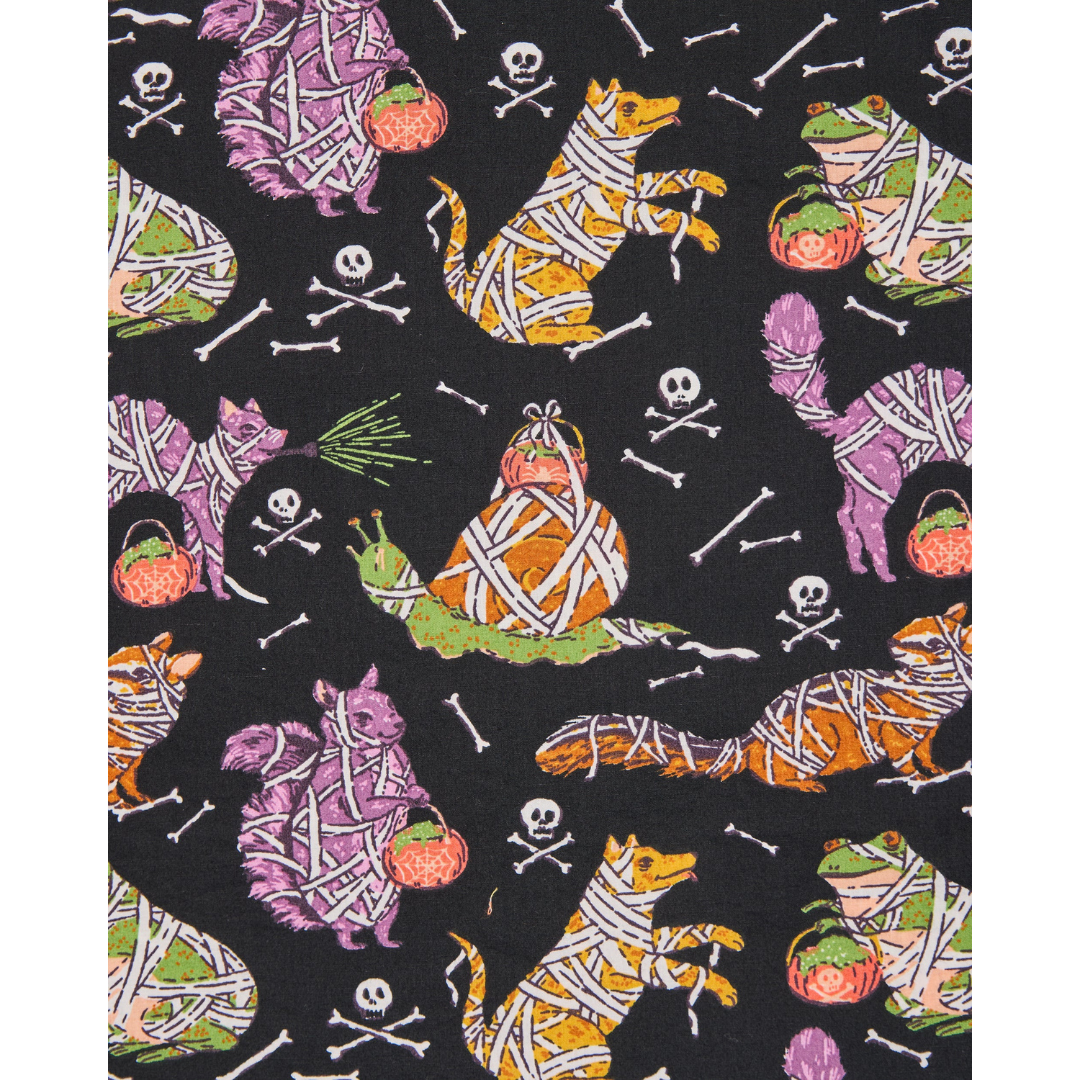 Halloween-themed fabric with mummy animals and bones on a black background