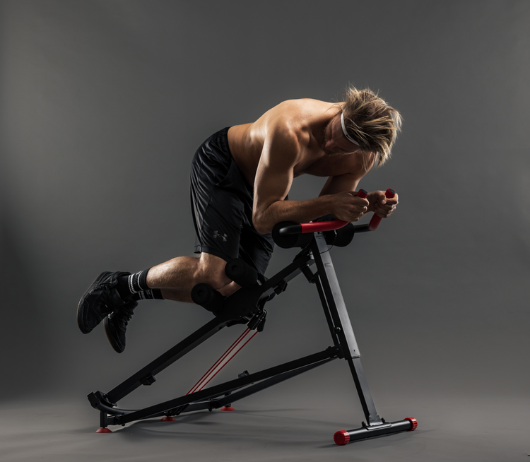 Man exercising on a black and red exercise bike against a gray background