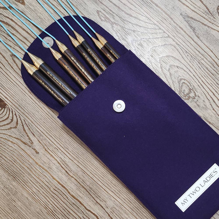 Set of makeup brushes in a navy blue case on a wooden surface