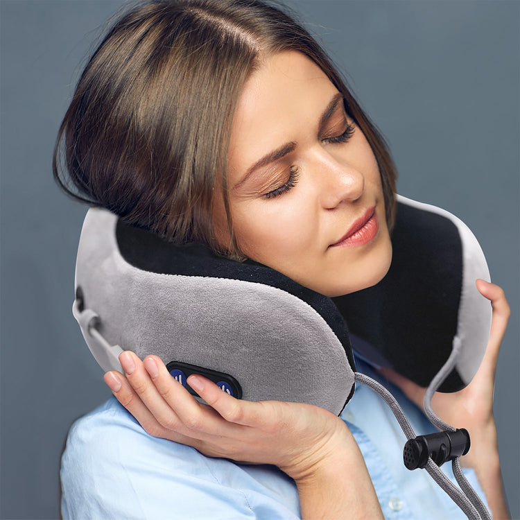 Woman using a travel neck pillow against a gray background