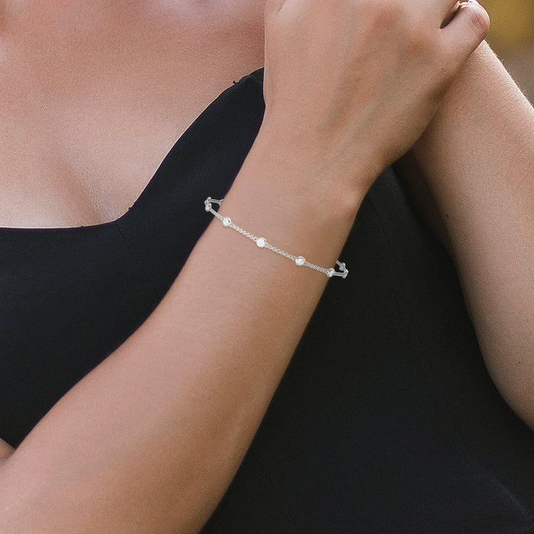 Silver bracelet on a wrist with a blurred background