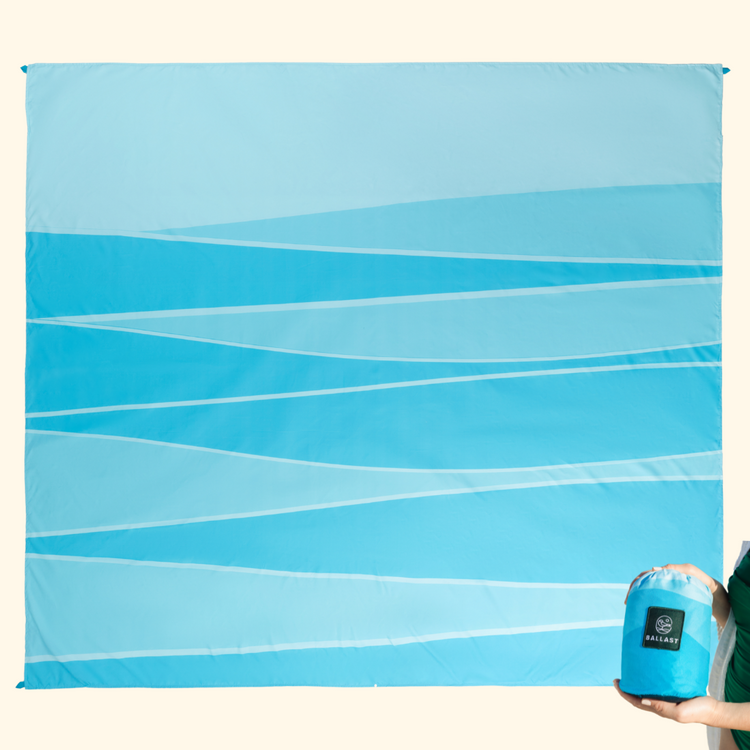 Blue patterned blanket with a can of fabric spray on a white background