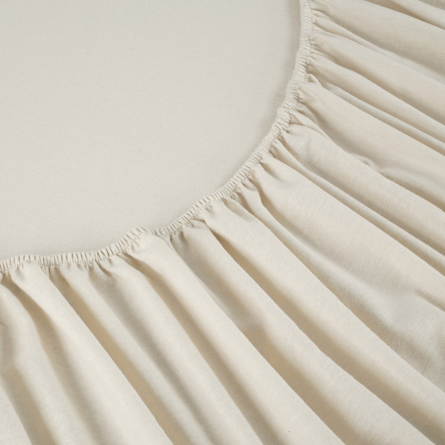 Close-up of a beige fitted sheet on a bed
