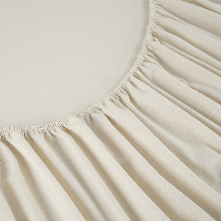 Close-up of a beige fitted sheet on a bed