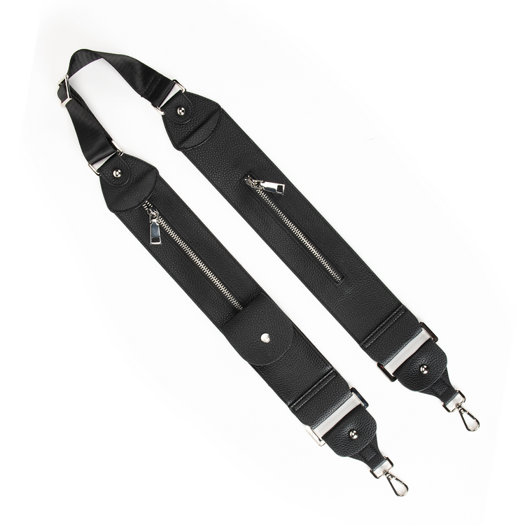 Adjustable black strap with zipper pockets and D-ring tabs, made of pebbled imitation leather, designed to be worn over the shoulder.