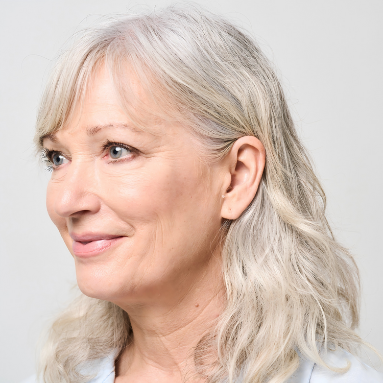 Close-up of a woman with gray hair against a light background