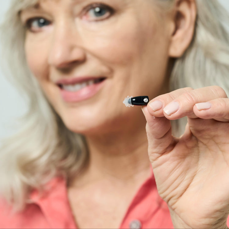 Woman holding a small electronic device close to her face