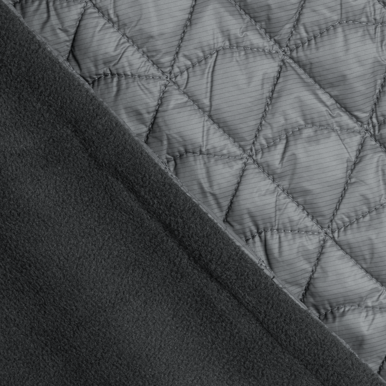 Close-up of quilted fabric with diamond pattern on a dark background