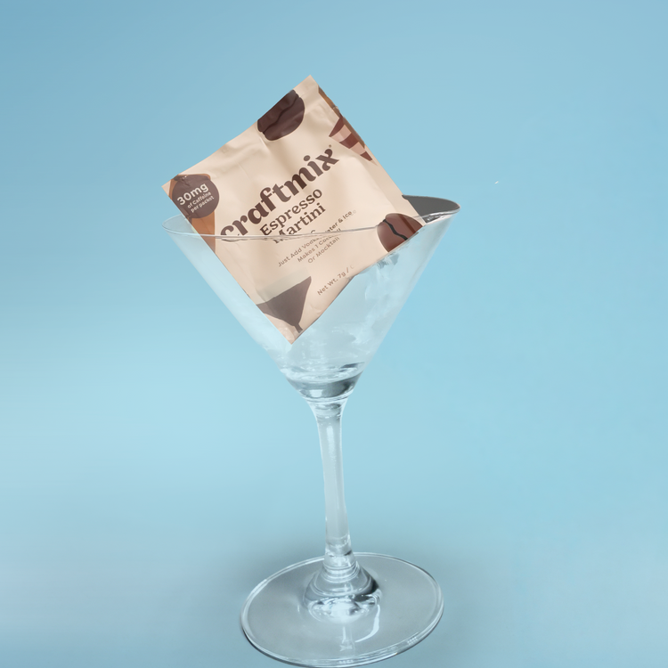 Craftmix Espresso Martini mix packet in a martini glass on a light blue background