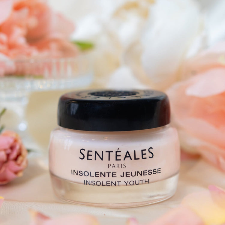Cosmetic jar labeled 'Senteçales' with flowers in the background