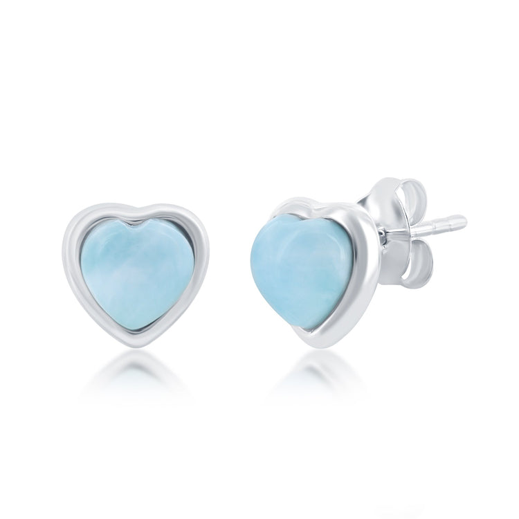 Heart-shaped earrings with light blue stones and silver frames on a white background