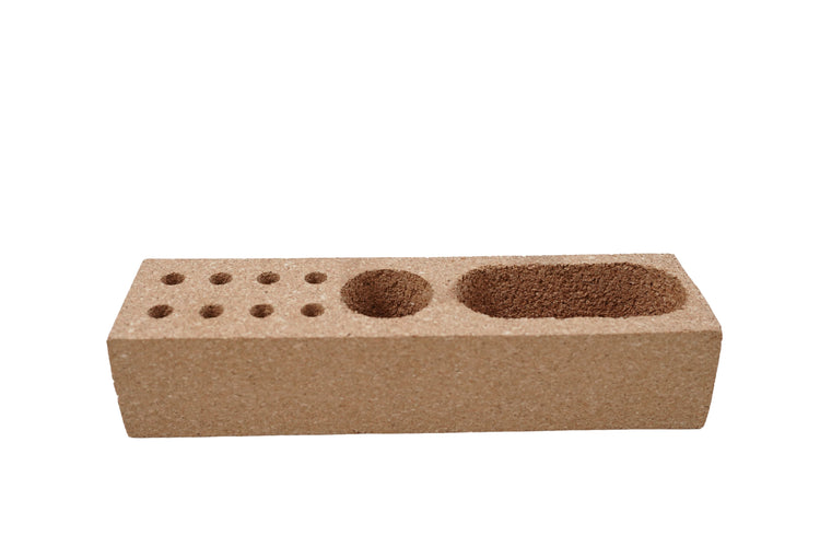 Cork brick with multiple holes on a white background