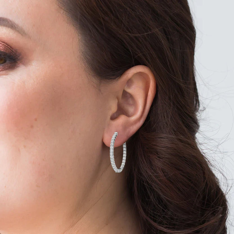 Close-up of a woman wearing a silver hoop earring with a blurred background