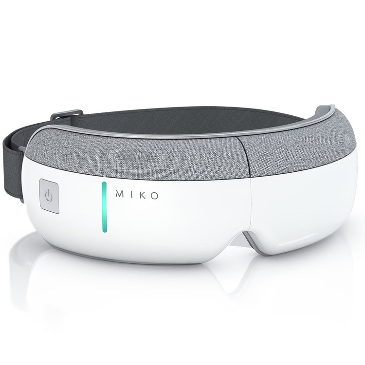 A white and gray Miko gaze eye massager with a sleek ergonomic design, featuring a power button on the front and contours around the eyes.