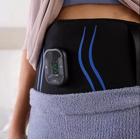 Person wearing a black waist trainer with digital display on a neutral background