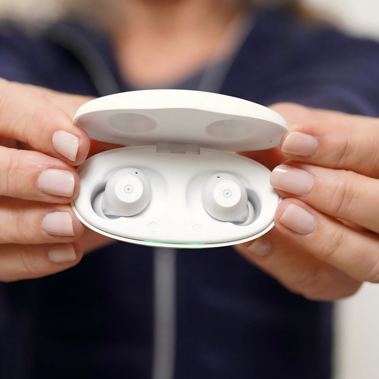 Person holding a white case with wireless earbuds inside