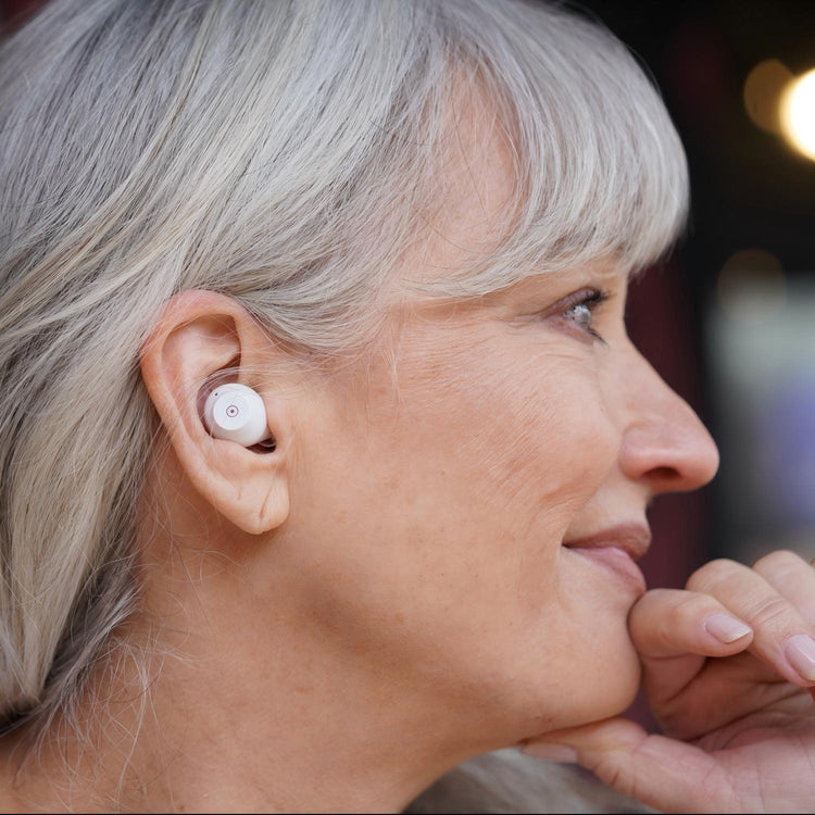 Woman wearing a white wireless earbud in her ear.