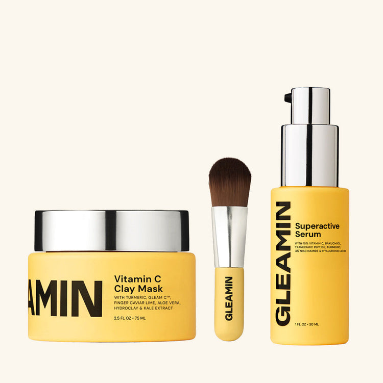 Gleamin skincare products including a jar, serum, and brush on a white background