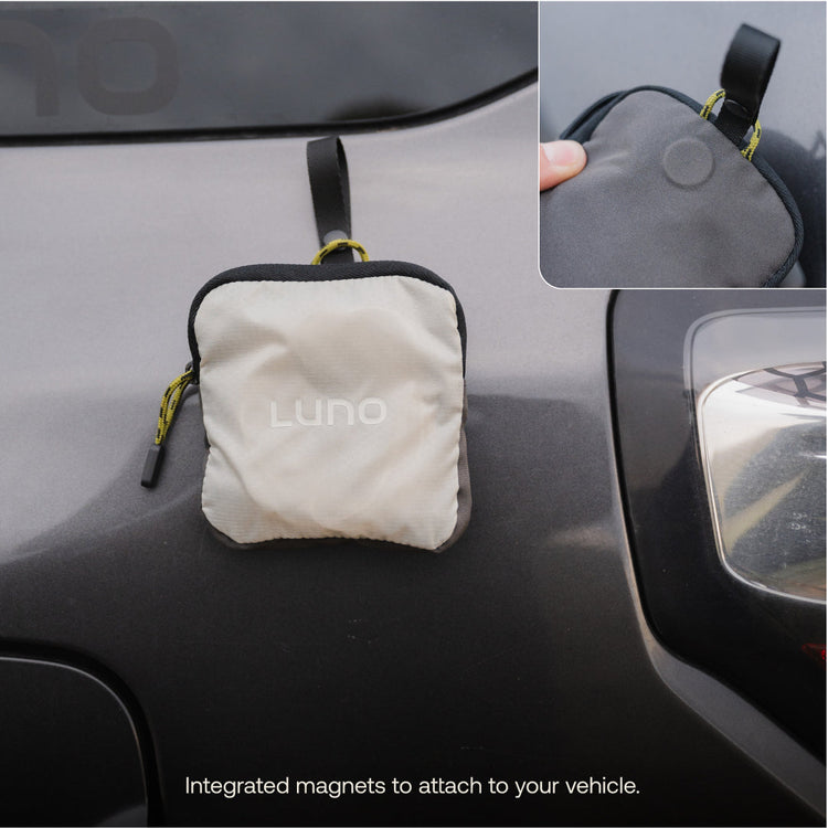 White pouch with black trim attached to a car using magnets, featuring the brand 'LUNO'.