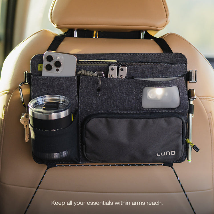 The Luno® Seatback Organizer is a must-have for car camping, attaching to a tan car seat and featuring multiple pockets for your smartphone, sunglasses, keys, pen, flashlight, and travel mug. Keep all essentials within reach!.