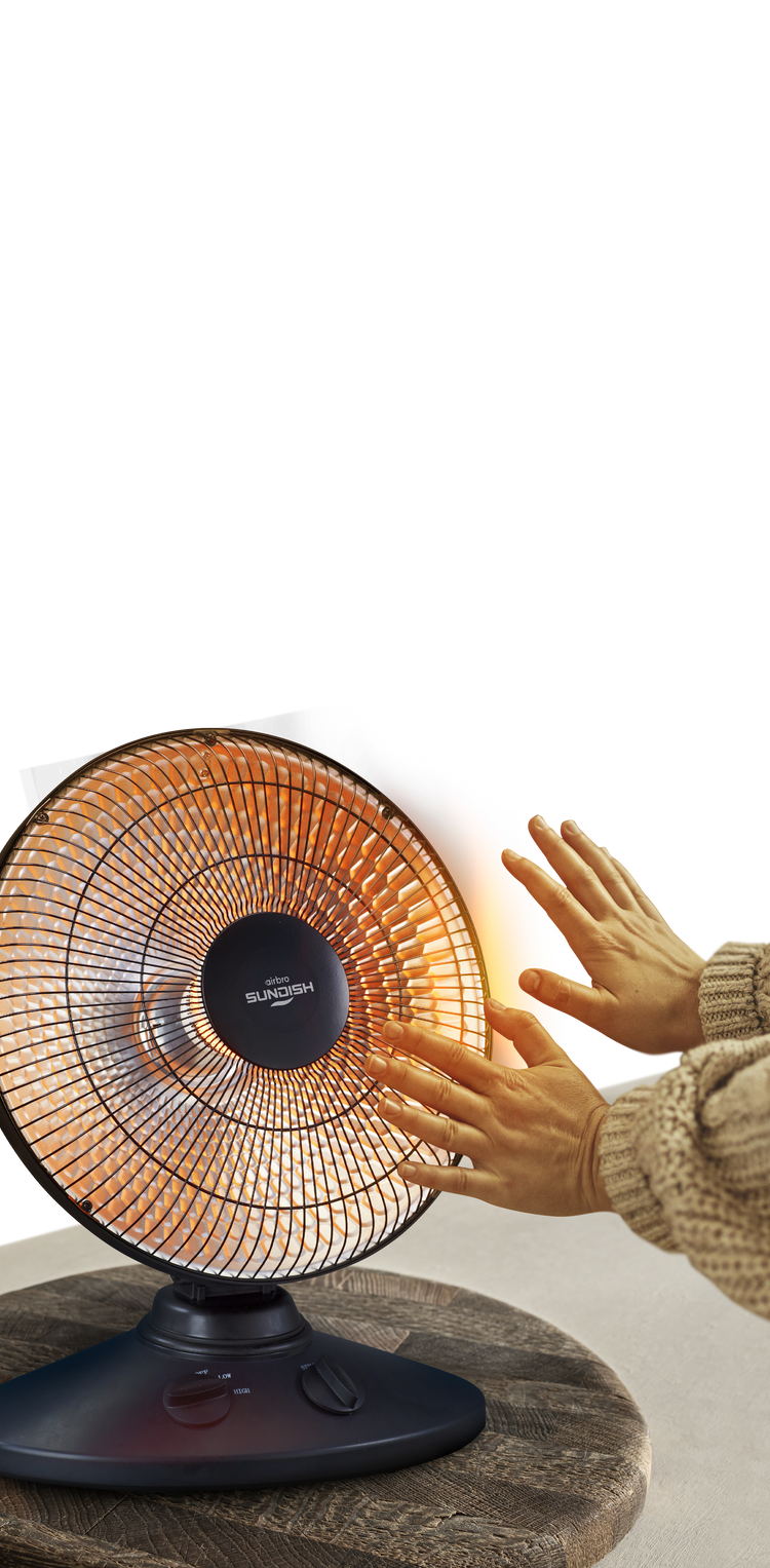 Person using a small electric heater with a white background