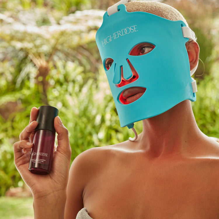 Person wearing a blue face mask outdoors holding a bottle.