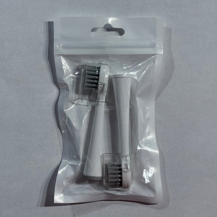 Clear plastic packaging with a hairbrush inside on a gray background