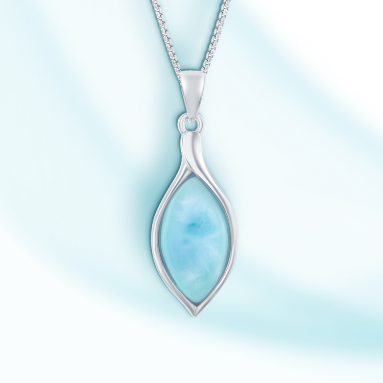 Silver pendant with a blue stone on a light blue background