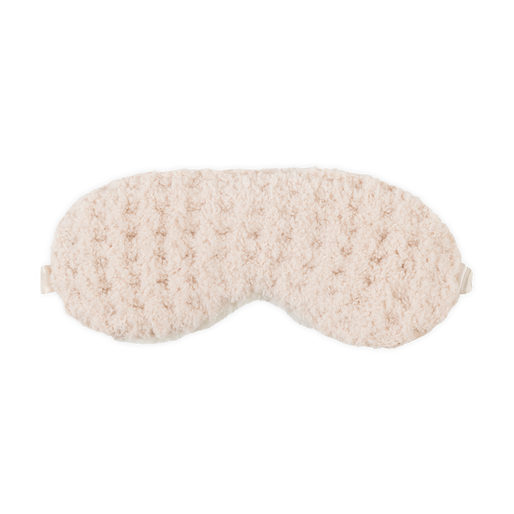 Beige fluffy eye mask on a white background