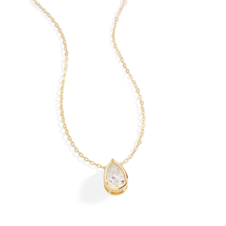 Gold necklace with a teardrop-shaped diamond pendant on a white background