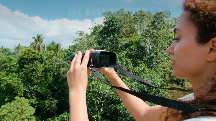 Woman taking a photo with a camera in a forest setting