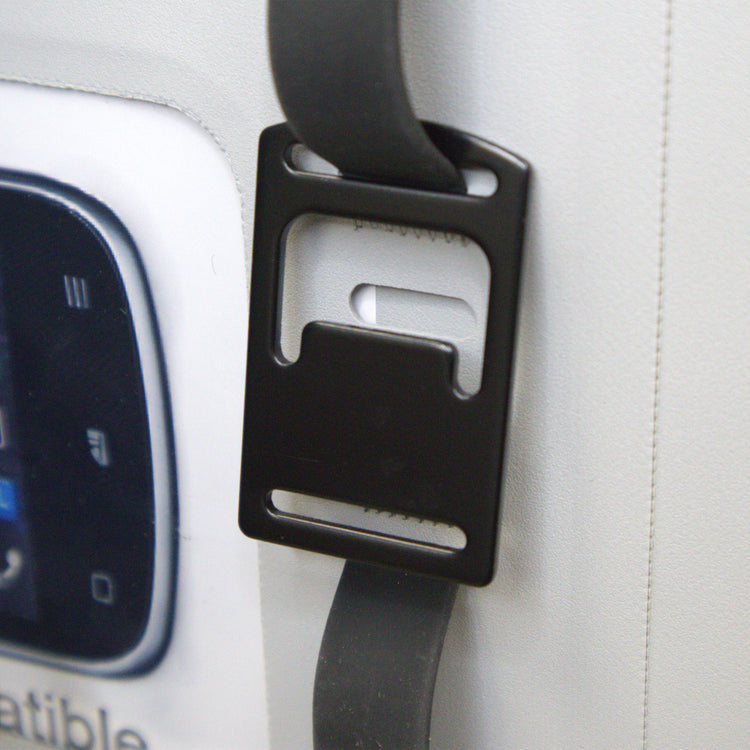 Car seat belt buckle attached to a car seat with a visible car console in the background.