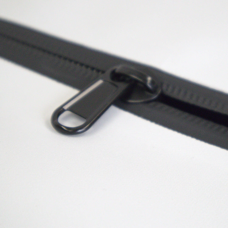 Close-up of a black zipper on a white background