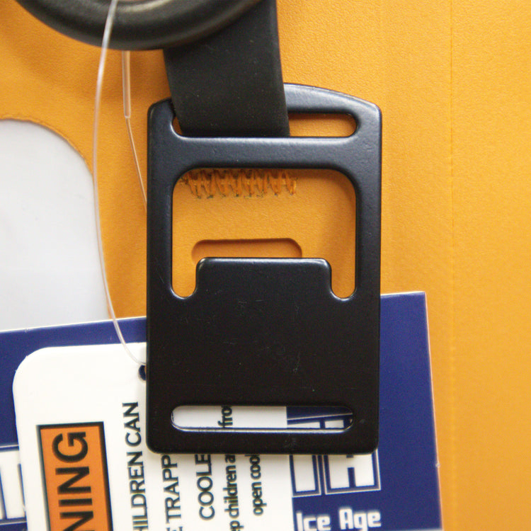 Black plastic clip on a yellow background with a warning label.