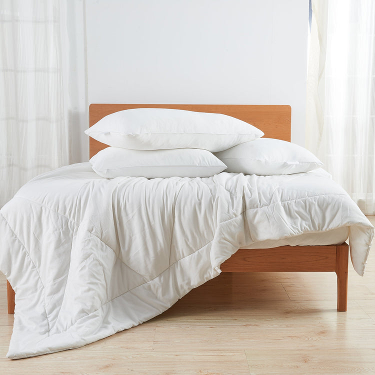 Bed with white bedding and pillows in a bright room