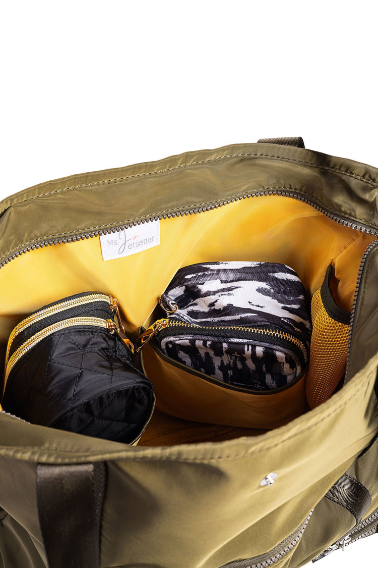 Open green bag with yellow interior showing a camouflage-patterned item.