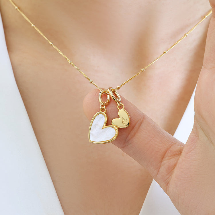 Gold necklace with heart-shaped pendants on a blurred background