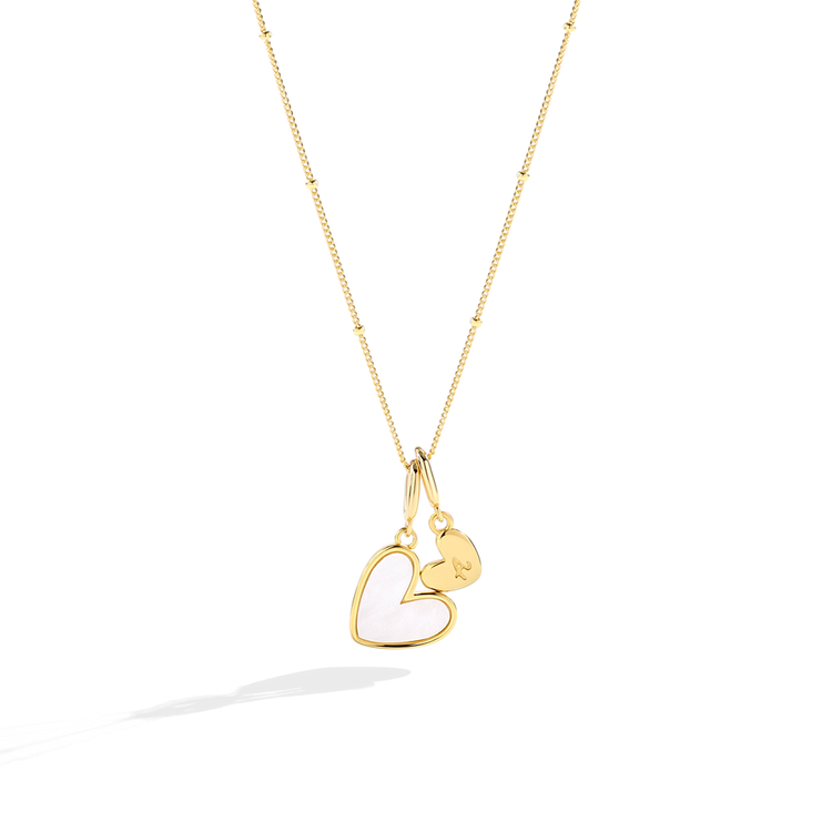 Gold necklace with a heart-shaped pendant on a white background