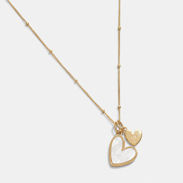 Gold necklace with a heart-shaped pendant on a white background