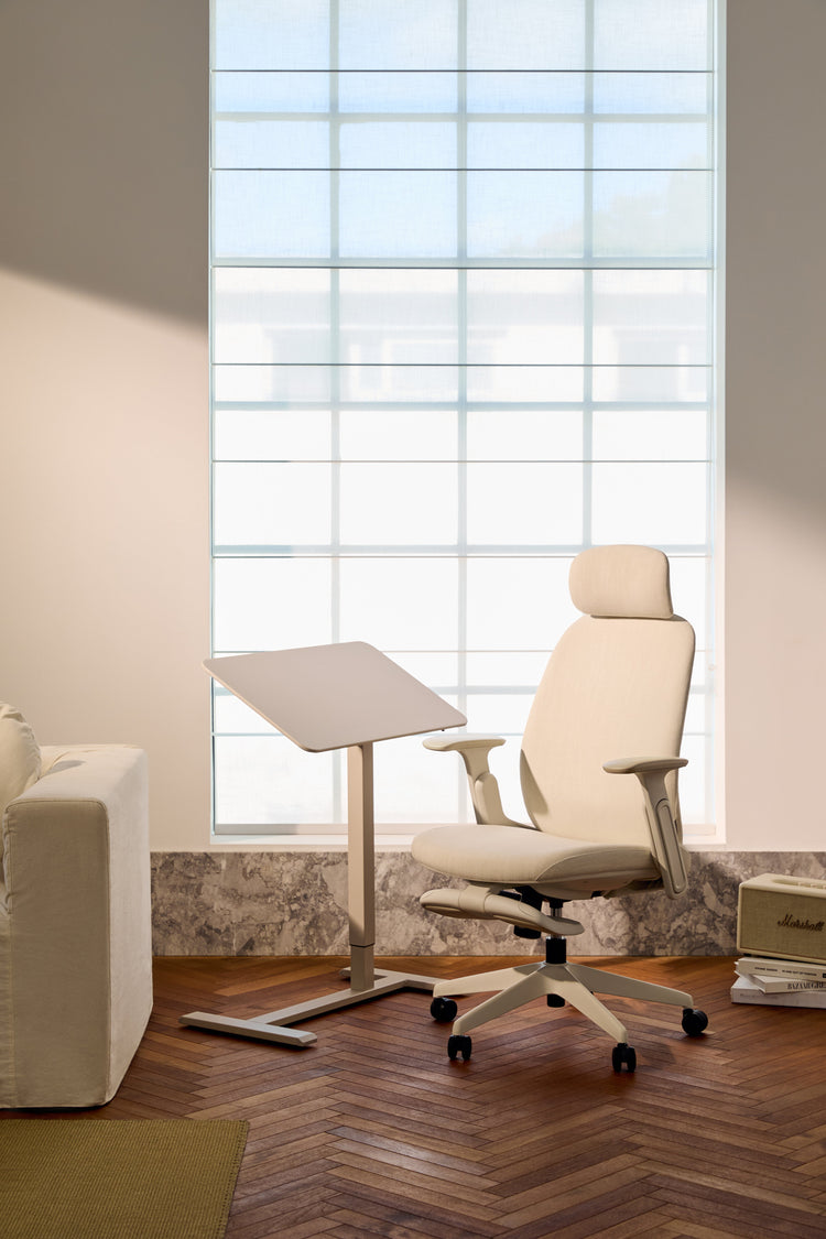 Modern office chair in a room with large windows and a desk.