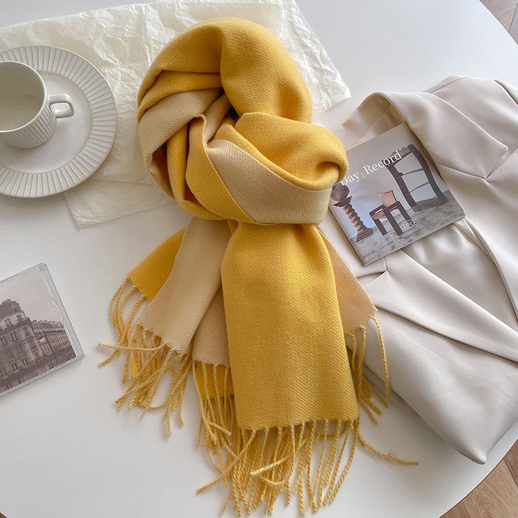 Yellow scarf with fringes on a white surface with a cup and cards.