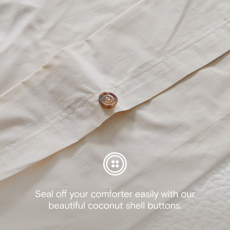 Close-up of a beige comforter with coconut shell buttons and text overlay.