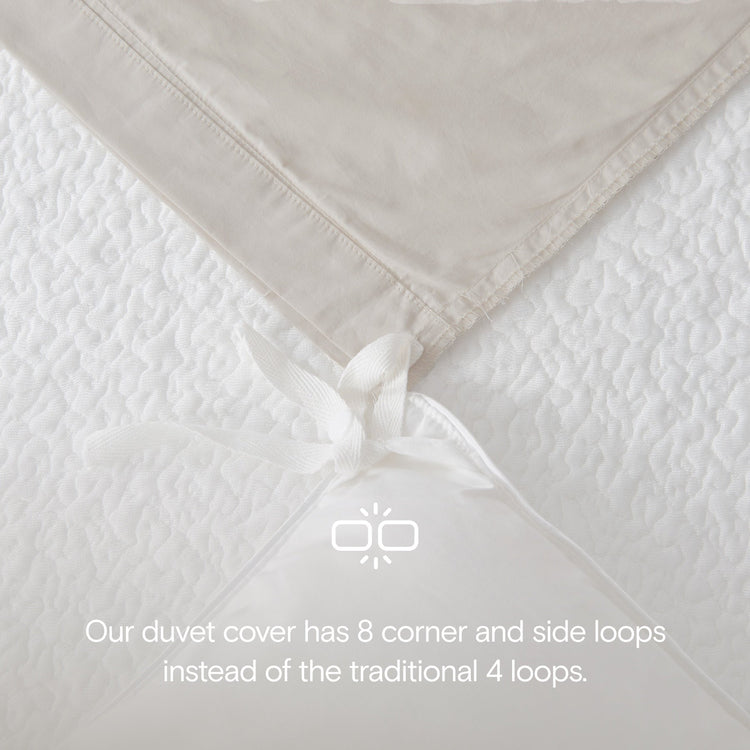 Close-up of a beige duvet cover with corner and side loops on a white background