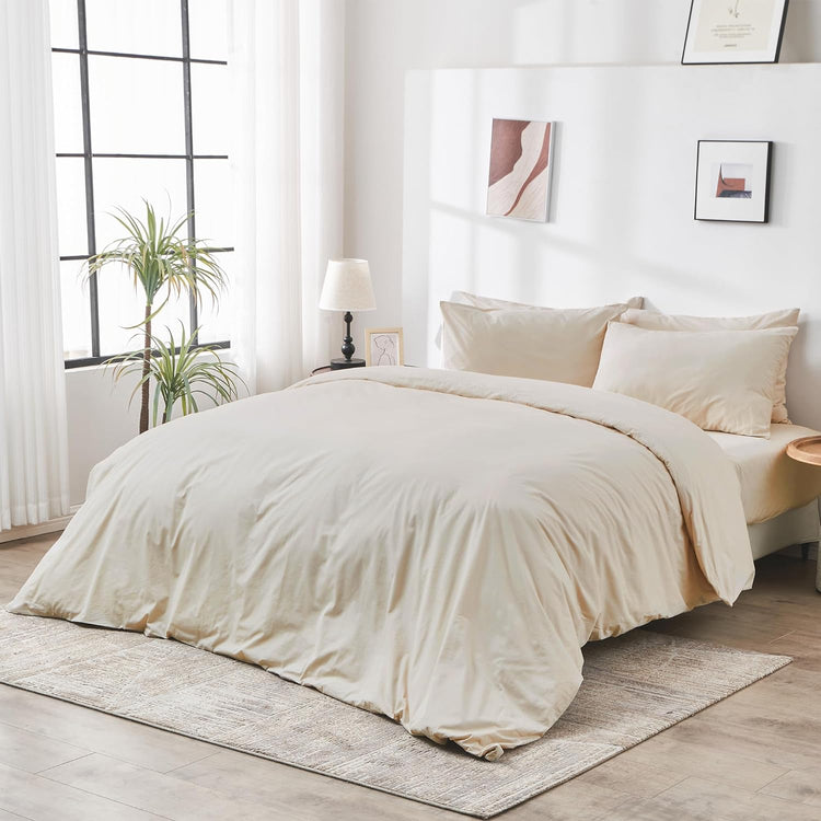 Neatly made bed with beige bedding in a bright bedroom.
