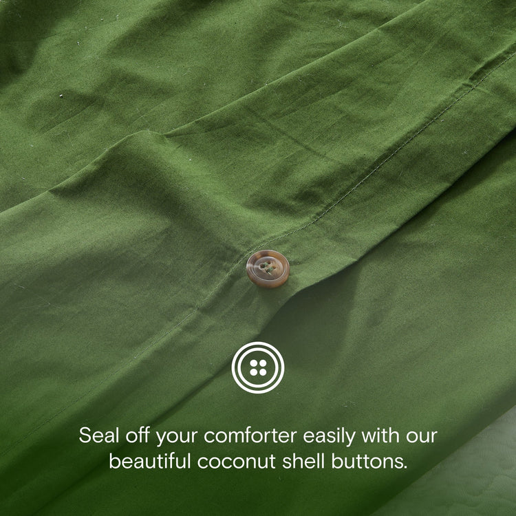 Close-up of a green fabric with a coconut shell button and text about sealing off a comforter.