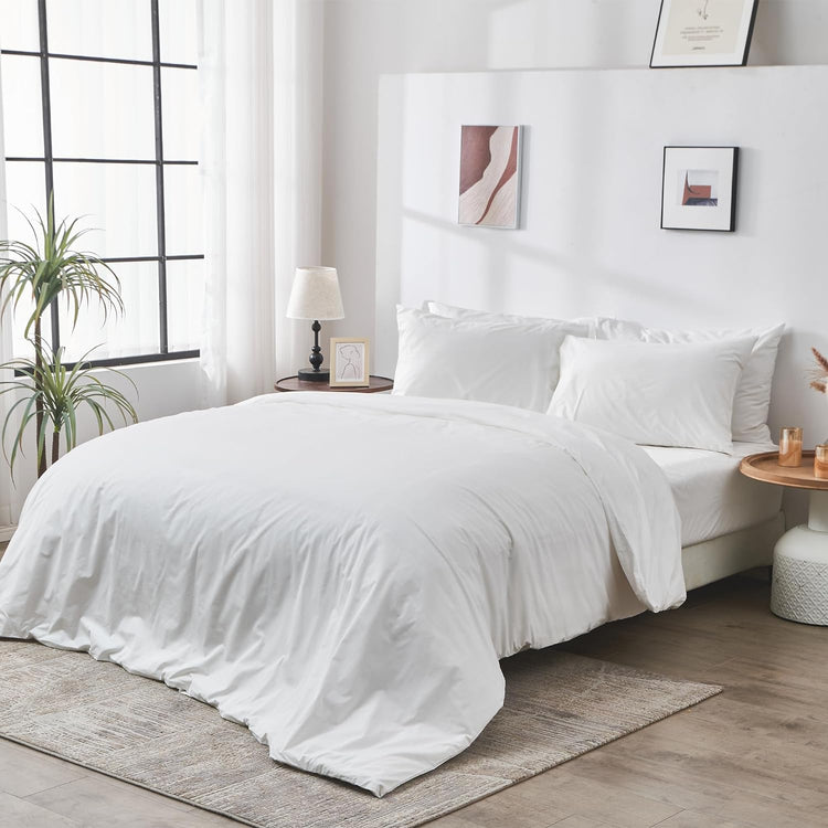 Neatly made bed with white bedding in a bright bedroom.